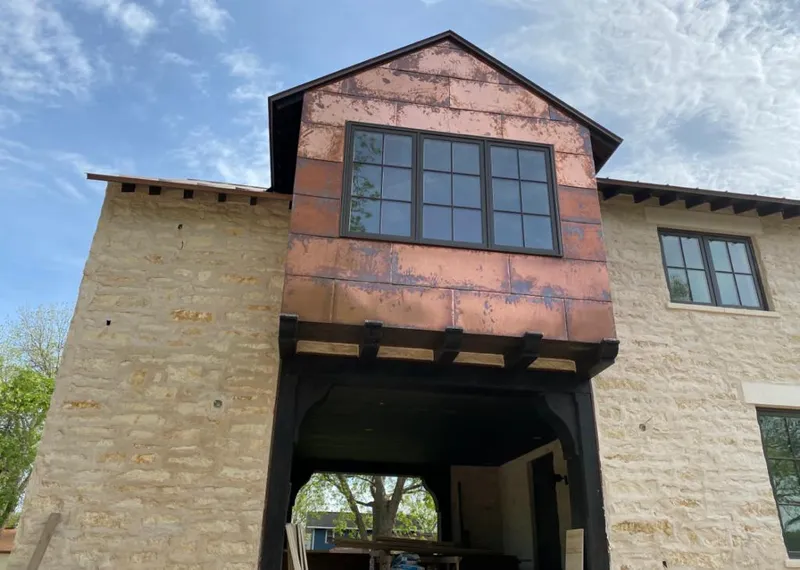 Copper metal panel facade on a stone building for Roof Repair in Elkhorn